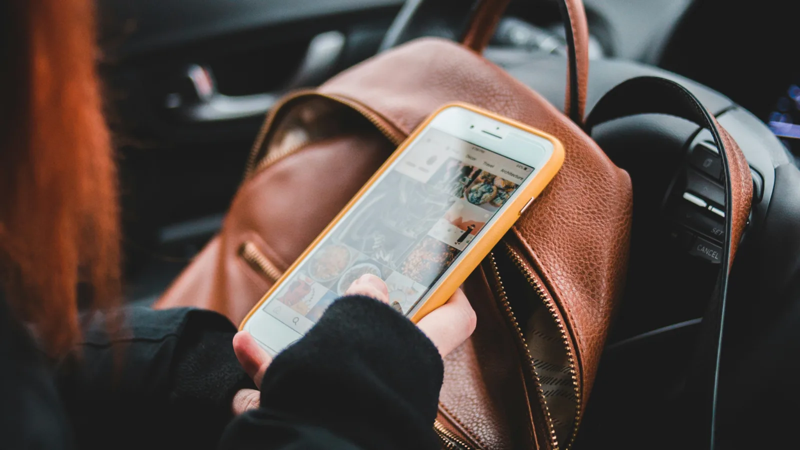 Photo of a woman using a mobile phone in a car